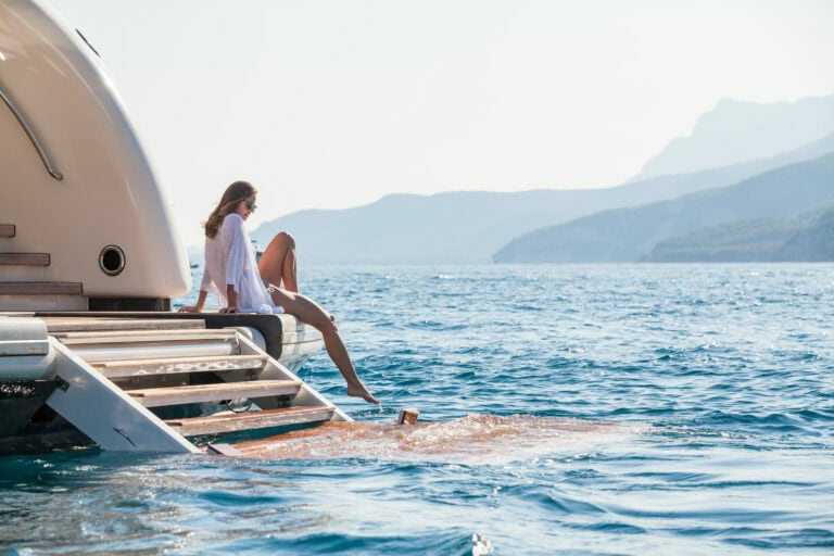 lady sitting on the swim deck of the Alia Yachts RÜYA looking out to sea