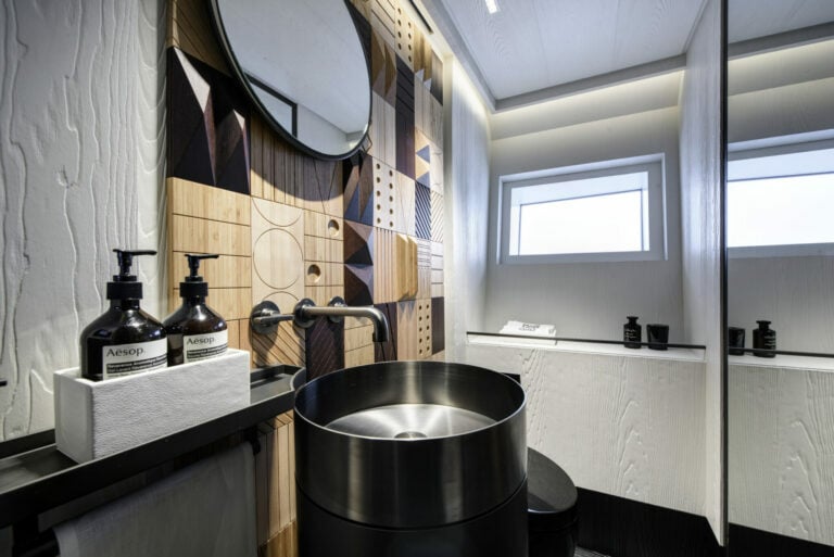 Bathroom suite with steel sink and wooden wall